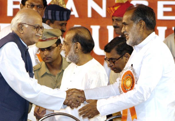 TOPSHOT - India's Deputy Prime Minister Lal Krishna Advani (L) greets former Indian Prime Minister Chandra Shekhar (R) during the 103rd birthday celebration function of Indian philosopher Shyama Prasad Mukherjee, in Calcutta, 06 July 2003. Advani is on a one-day visit to the Indian city,state capital of West Bengal. (Photo by DESHAKALYAN CHOWDHURY / AFP) (Photo by DESHAKALYAN CHOWDHURY/AFP via Getty Images)